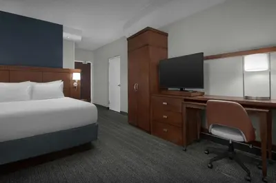 a hotel room with a bed and a desk with a television at Courtyard Philadelphia Great Valley/Malvern in Malvern
