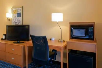 a room with a desk with a computer and a tv at Fairfield Inn & Suites Kennett Square in Kennett Square