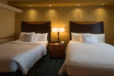 a hotel room with two beds and a lamp at Fairfield Inn & Suites Kennett Square in Kennett Square