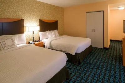 a hotel room with two beds and a door at Fairfield Inn & Suites Kennett Square in Kennett Square