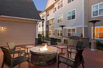 a patio with a fire pit and chairs and a grill at Residence Inn Mt. Laurel at Bishop's Gate in Mount Laurel