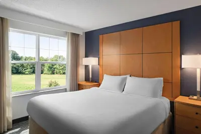 a bedroom with a large bed and a large window at Residence Inn Mt. Laurel at Bishop's Gate in Mount Laurel