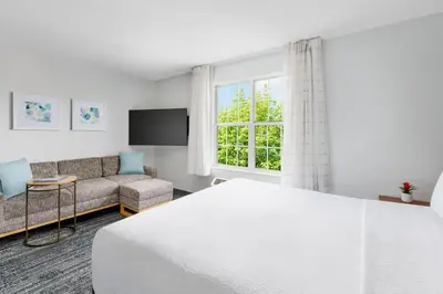 a bedroom with a bed and a couch and a window at TownePlace Suites Philadelphia Horsham in Horsham
