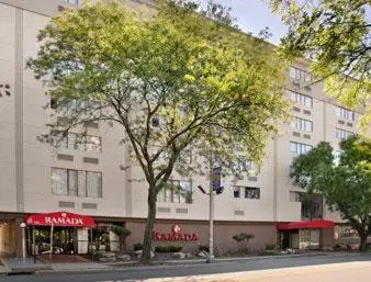 a large white building with a tree in front of it at Ramada by Wyndham East Orange in East Orange
