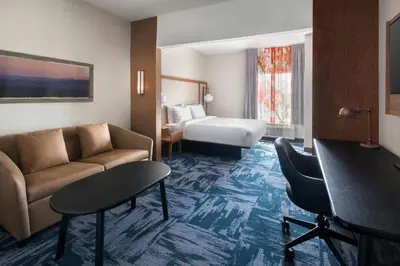 a hotel room with a couch and a bed at Fairfield Inn & Suites by Marriott Somerset in Somerset