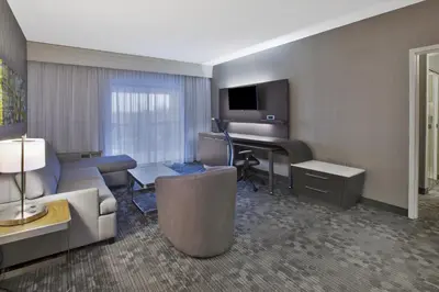 a hotel room with a couch and a piano at Courtyard by Marriott Somerset in Somerset