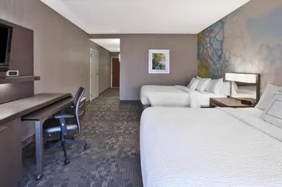 a hotel room with two beds and a desk at Courtyard by Marriott Somerset in Somerset