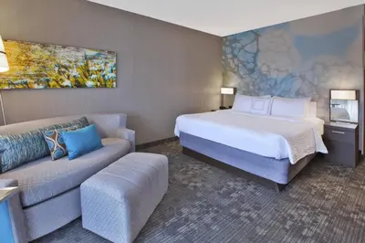 a hotel room with a bed and a couch at Courtyard by Marriott Somerset in Somerset