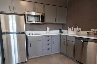 a kitchen with white cabinets and a stainless steel refrigerator at Residence Inn by Marriott Princeton at Carnegie Center in Princeton