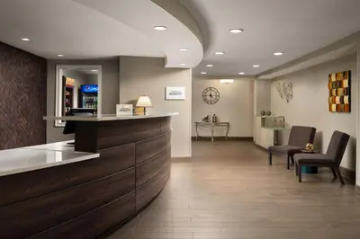 a lobby of a hospital with chairs and a counter at Residence Inn Mount Olive At International Trade Center in Stanhope