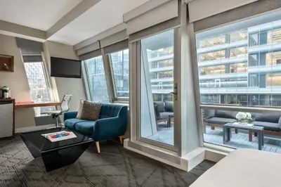 a hotel room with a view of a living room at The Gotham Hotel in New York