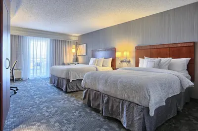 a hotel room with two beds with white sheets at Courtyard by Marriott Harrisburg West/Mechanicsburg in Mechanicsburg