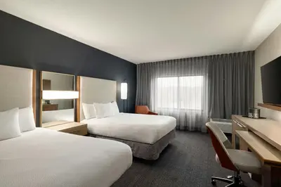 a hotel room with two beds and a desk at Courtyard Wilmington Brandywine in Wilmington