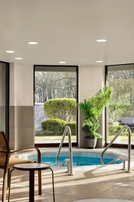 a lobby with a pool and two chairs and a table at Courtyard Wilmington Brandywine in Wilmington