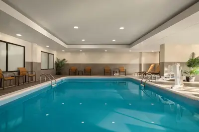 a pool in a hotel with chairs and tables at Courtyard Wilmington Brandywine in Wilmington