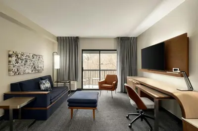 a hotel room with a desk and a couch at Courtyard Wilmington Brandywine in Wilmington