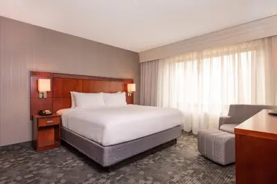 a hotel room with a bed and a chair at Courtyard by Marriott Newark-University of Delaware in Newark
