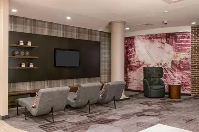 a waiting room with chairs and a flat screen tv at Courtyard by Marriott Newark-University of Delaware in Newark