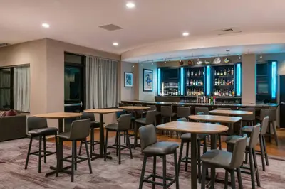 a restaurant with tables and chairs and a bar at Courtyard by Marriott Newark-University of Delaware in Newark