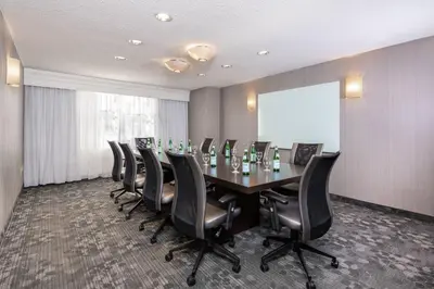 a conference room with a long table and leather chairs at Courtyard by Marriott Newark-University of Delaware in Newark