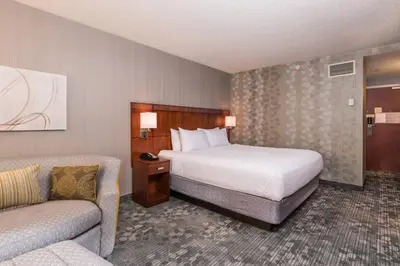 a hotel room with a bed and a couch at Courtyard by Marriott Newark-University of Delaware in Newark