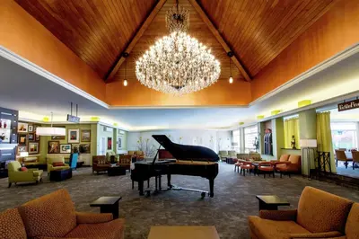 a living room with a piano and a chandelier at Hilton Garden Inn New York/Staten Island in Staten Island