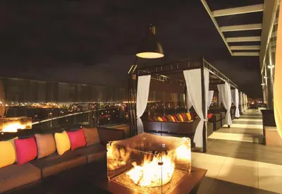 a room with a couch on a balcony at night at Hilton Garden Inn New York/Staten Island in Staten Island