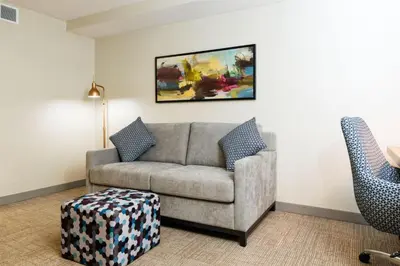 a living room with a couch and a painting on the wall at Hilton Garden Inn New York/Staten Island in Staten Island