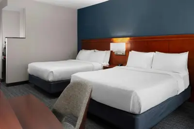 a hotel room with two beds and a table at Courtyard Reading Wyomissing in Reading