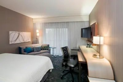 a hotel room with a bed and a desk with a computer at Courtyard by Marriott Scranton Montage Mountain in Moosic