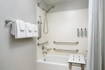 a bathroom with a shower and a white tub at Courtyard by Marriott Scranton Montage Mountain in Moosic
