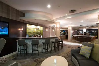 a hotel lobby with a bar with stools at Courtyard by Marriott Middletown Goshen in Middletown