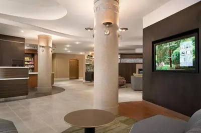 a lobby with columns and a table and a tv at Courtyard by Marriott Middletown Goshen in Middletown