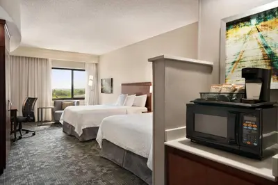 a hotel room with two beds and a tv at Courtyard by Marriott Middletown Goshen in Middletown