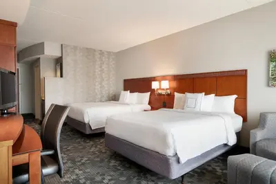 a hotel room with two beds and a television at Courtyard by Marriott Ewing Princeton in Ewing