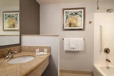 a bathroom with a sink and a tub and a shower at Courtyard by Marriott Ewing Princeton in Ewing