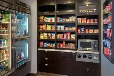 a kitchen with a refrigerator and a pantry with food at Courtyard by Marriott Ewing Princeton in Ewing