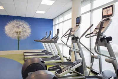 a gym with rows of tread machines in a room at SpringHill Suites Ewing Township Princeton South in Ewing