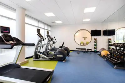 a gym with treadmills elliptical machines and a mirror at SpringHill Suites Ewing Township Princeton South in Ewing