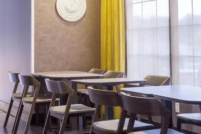 a row of tables and chairs with yellow curtains at SpringHill Suites Quakertown Pennsylvania in Quakertown