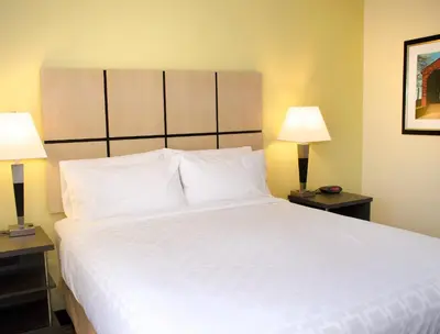 a bedroom with a large white bed with two lamps at Candlewood Suites - Lancaster West by IHG in Lancaster
