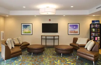 a waiting room with couches and a flat screen tv at Candlewood Suites - Lancaster West by IHG in Lancaster