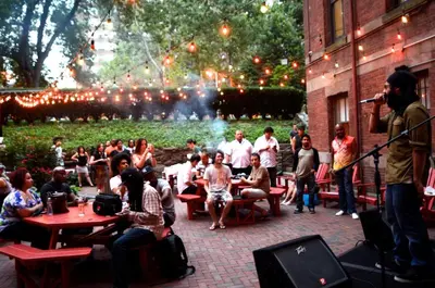 a group of people sitting in a courtyard with a microphone at HI New York City Hostel in New York