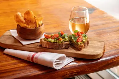 a wooden table with a plate of food and a glass of beer at Hyatt Centric Wall Street New York in New York