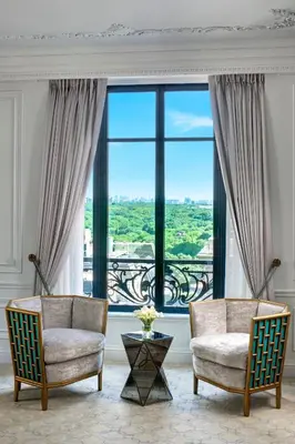 a living room with two chairs and a large window at The St. Regis New York in New York