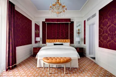 a bedroom with a large bed and a chandelier at The St. Regis New York in New York