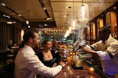 a group of people sitting at a bar at InterContinental New York Times Square by IHG in New York