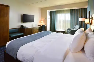 a hotel room with a large bed and a television at Tioga Downs Casino and Resort in Nichols