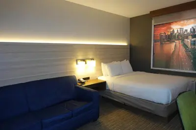 a hotel room with a bed and a couch at Country Inn & Suites by Radisson, Staten Island in Staten Island