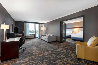 a hotel room with a bed and a desk and a mirror at Wyndham Lancaster Resort and Convention Center in Lancaster